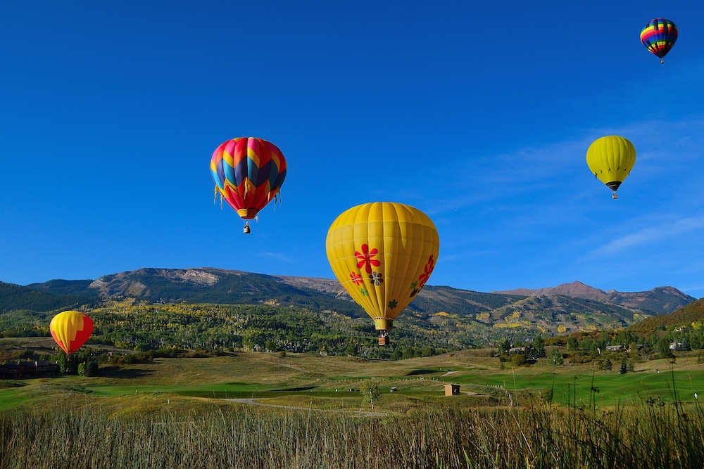 Hot air balloons flying over the mountains in Snowmass