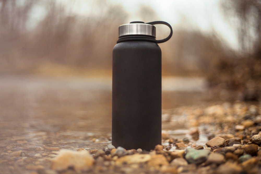 Water bottle sitting on bank of stream